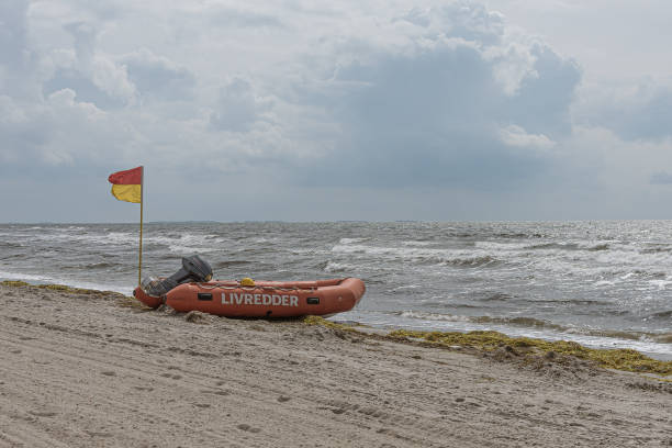 rubber boat and a red and yellow flag at a beach meaning it has lifeguard supervision, Karrebæksminde, Denmark, August 9, 2021