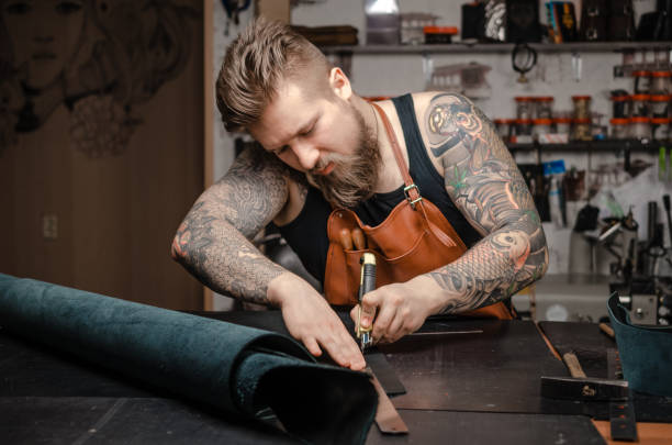 istock Leather Currier creating new leatherwork in his tanner shop 1361090358