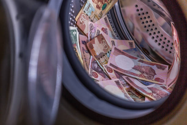 money Laudry Currency notes in a washing machine. money laundering stock pictures, royalty-free photos & images