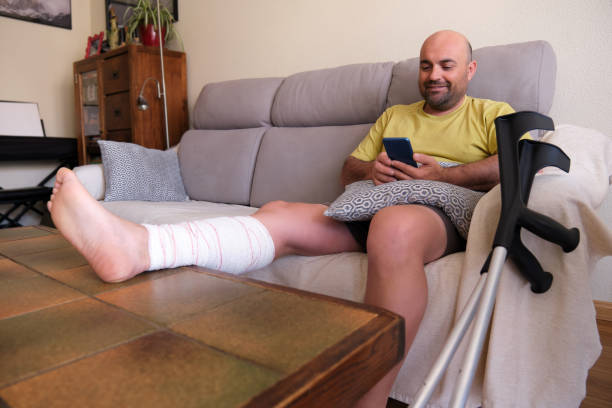 istock A mature man with injured leg using smart phone at home 1361094126