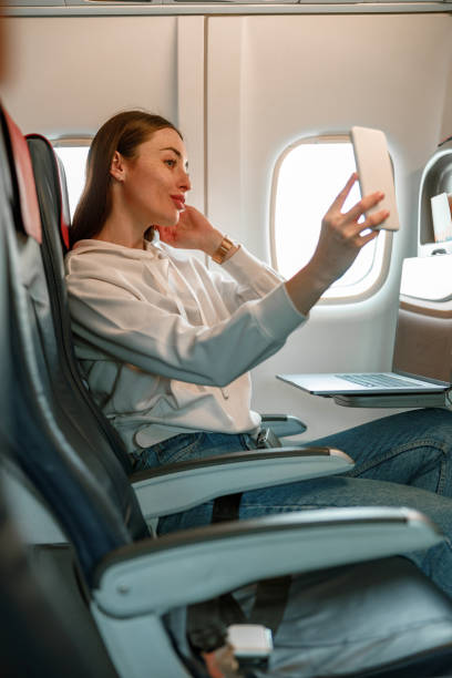 istock Young woman making selfie in passenger airplane 1361095730