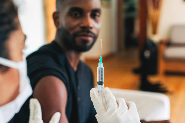 istock Frontline worker giving coronavirus vaccine to man at home 1361096020
