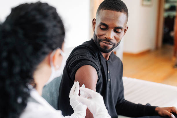 Young african man getting vaccinated at home