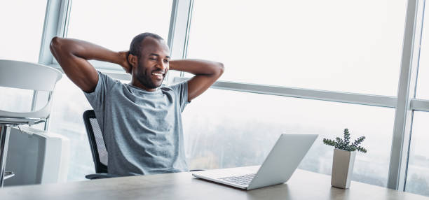istock Website header of Young businessman looking on the screen in spacious bright office. 1361099151
