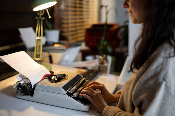 istock Woman using an old vintage typewriter at home 1361101285