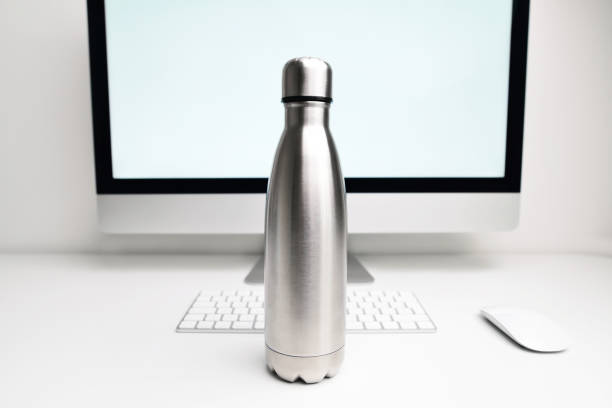 istock Steel thermo bottle for water on office table near computer and documents. Black-matte, empty stainless thermo water bottle close-up. Stainless thermos water bottle. 1361101359