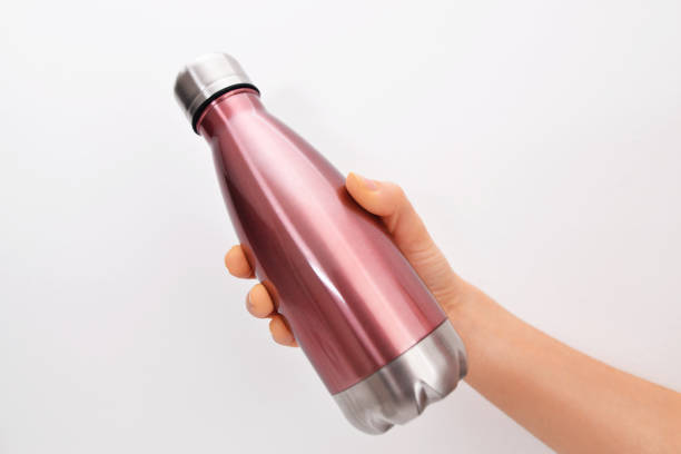 Close-up of female hand, holding reusable steel stainless eco thermo water bottle with mockup, on white background. Be plastic free. Zero waste. Be plastic free. Zero waste. blue reusable water bottle stock pictures, royalty-free photos & images