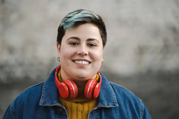 Photo of Handsome non-binary woman smiling outdoors