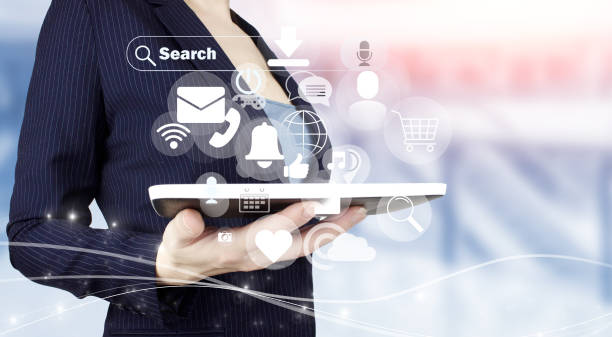 istock Social media or social network notification. Hand hold white tablet with digital hologram social media icons sign on light blurred background. Communication and network concept. 1361112820