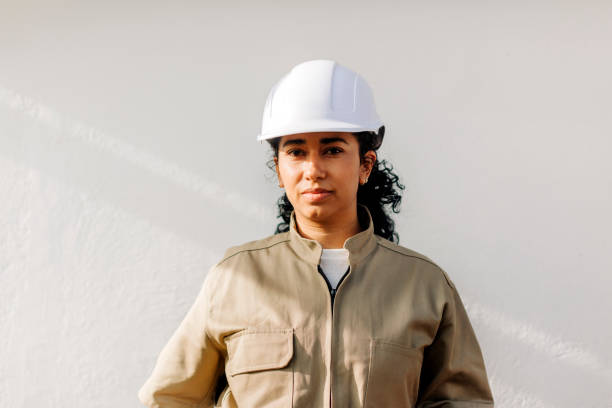 ritratto di una donna ispanica elettricista in uniforme e cappello rigido - white hardhat foto e immagini stock