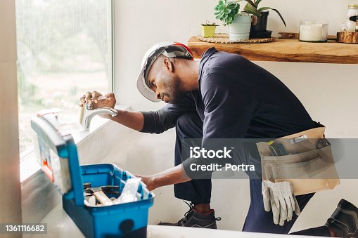 istock Plumber fixing a leaking bathroom faucet 1361116682