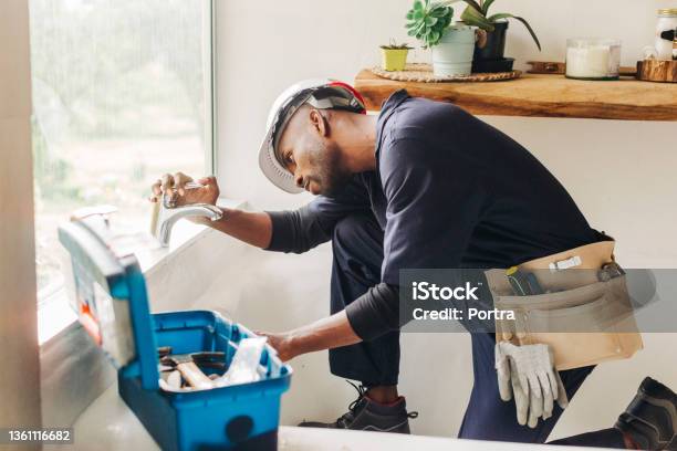 Plumber Fixing A Leaking Bathroom Faucet Stock Photo - Download Image Now - Plumber, Repairing, Residential Building