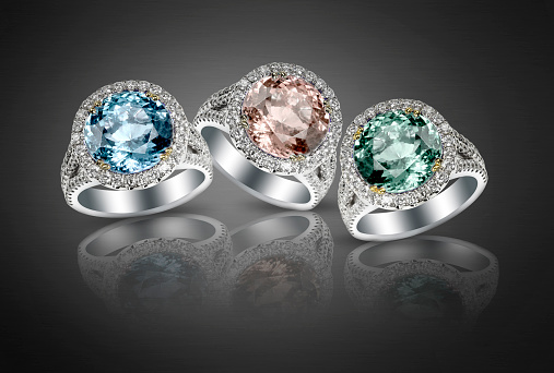 A set of diamond gemstone pastel fashion non traditional engagement fashion wedding rings on a black background. Jewelry