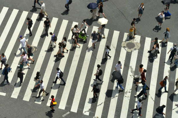 Crossing Japanese citizens crossing Shibuya Intersection on a hot summerday in Tokyo, Japan shibuya district stock pictures, royalty-free photos & images