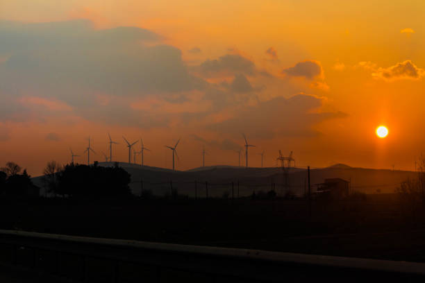 All the beauties of nature are in the hands of man. Silhouette of wind turbines with renewable energy source at a magnificent sunset.
