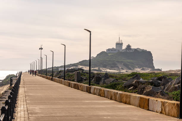 Newcastle, New South Wales, Australia - June, 23 2021: Nobbys Lighthouse at the end of Nobbys Beach marking the shipping entrance to Newcastle Harbour and an iconic landmark of the city of Newcastle.