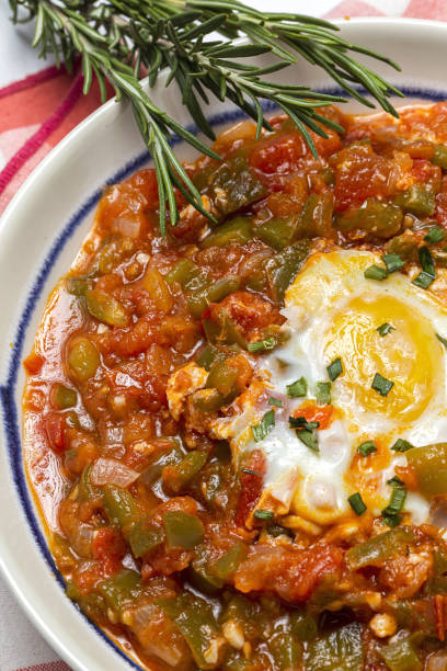 Vegetable dish pisto manchego made of tomatoes, zucchini, peppers, onions with fried egg Vegetable dish pisto manchego made of tomatoes, zucchini, peppers, onions with fried egg. Typical Spanish food machego stock pictures, royalty-free photos & images