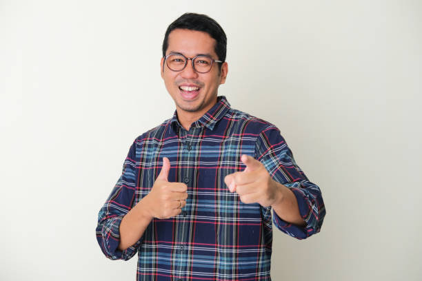 istock Adult Asian man pointing forward while giving thumb up 1361190740