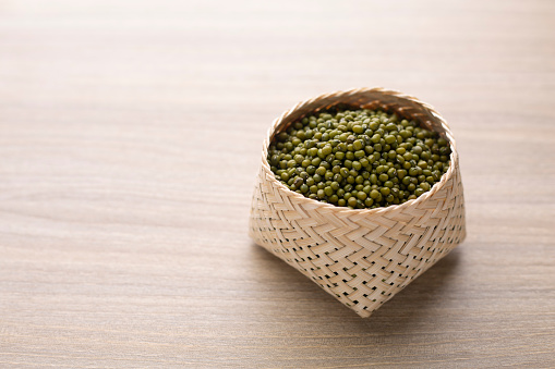 Organic mung bean in basket on wood table. Protein nutrition ingredient for vegetarian.