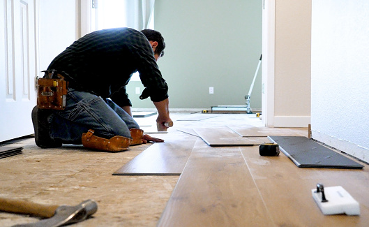 Hispanic man Worker Installing wooden vinyl floor