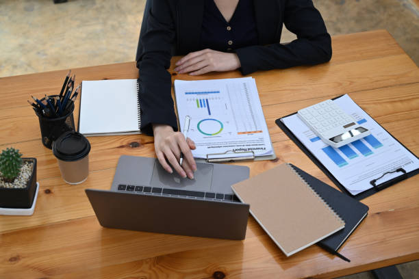 istock Cropped shot businesswoman working with laptop and analyzing financial graph reports. 1361194399