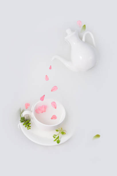 istock Pink petals drip from white porcelain teapot into cup. 1361198523