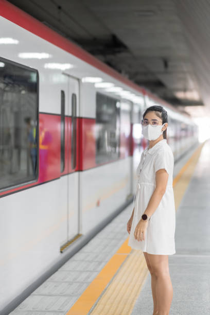 istock woman wearing Protective face mask prevention coronavirus inflection during waiting train. public transportation. social distancing, new normal and safety under covid-19 pandemic 1361200134