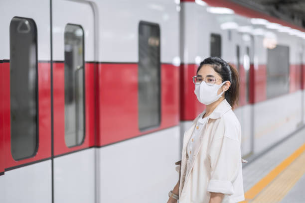 istock woman wearing Protective face mask prevention coronavirus inflection during waiting train. public transportation. social distancing, new normal and safety under covid-19 pandemic 1361200144