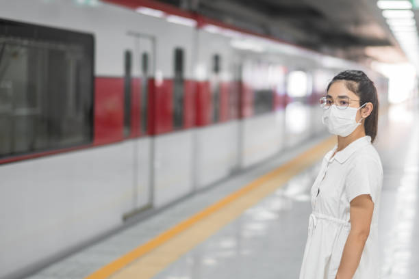 istock woman wearing Protective face mask prevention coronavirus inflection during waiting train. public transportation. social distancing, new normal and safety under covid-19 pandemic 1361200845