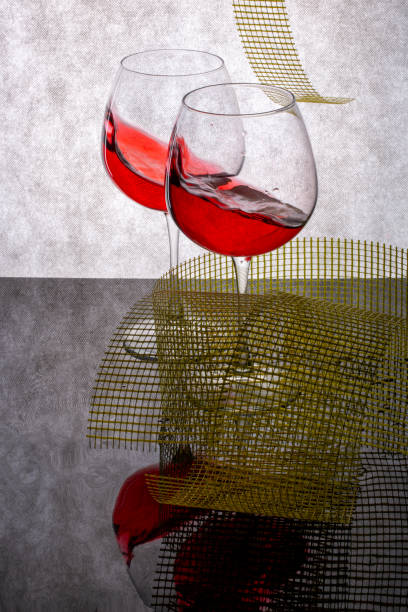 istock Still life with splashed wine in a glass and geometric shapes on a reflective surface 1361201683