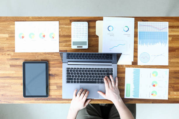 istock Man in office enters data from report into laptop 1361205169