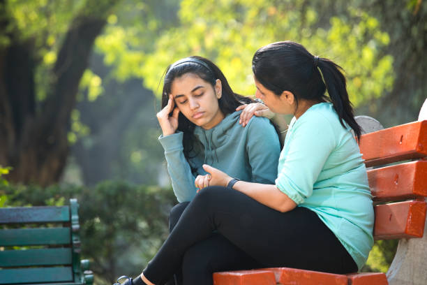 istock Mother comforting her stressed daughter at park 1361210385