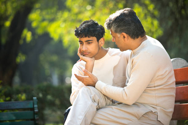 istock Father comforting his son at park 1361210462