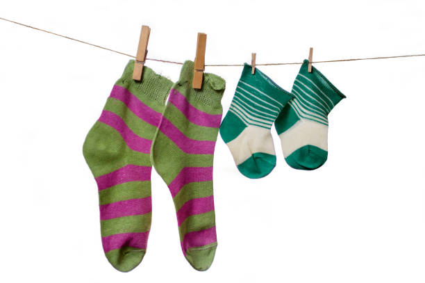 Large and small socks are dried on a rope. Adult and children's socks close-up on a white background.