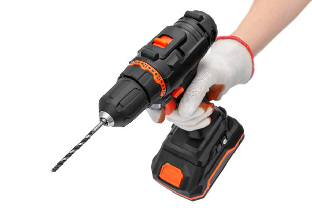 istock Worker's hand in gloves holding cordless drill-screwdriver. Isolated on white. 1361213294