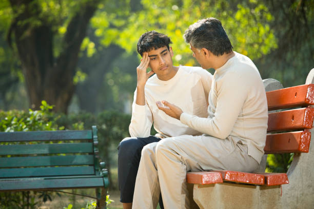 istock Father comforting his son at park 1361214454