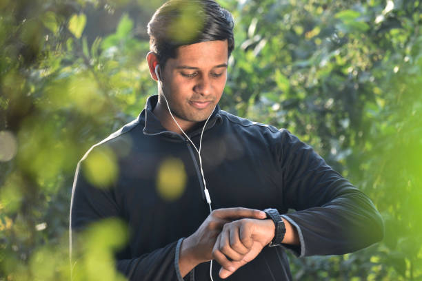 Smiling Man Using Smartwatch and Checking Physical Activity on Smartwatch stock photo