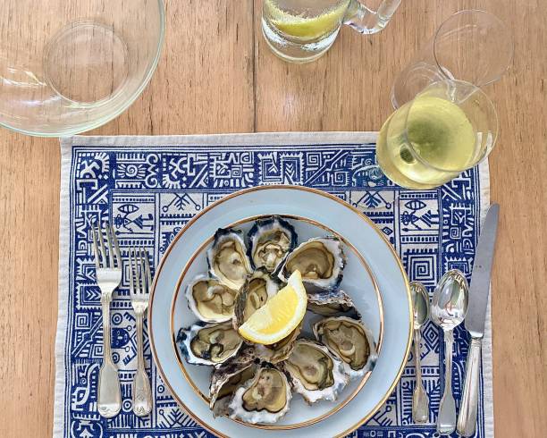 a dozen fresh shucked ocean oysters - food dinner prepared fish gourmet imagens e fotografias de stock