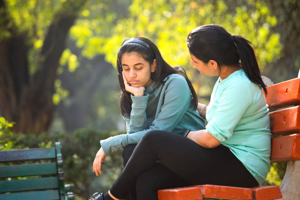 istock Mother comforting her stressed daughter at park 1361216192