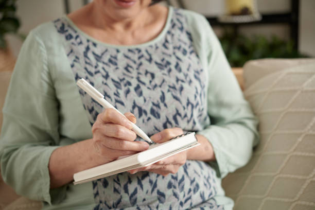 istock Senior Woman Writing in Diary 1361217639