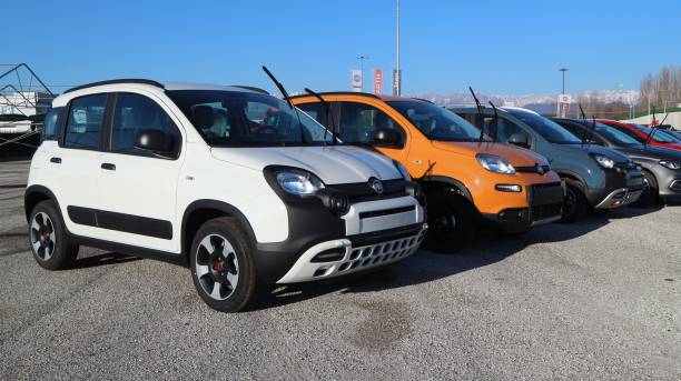 Fiat Panda Hybrid cars outside the official dealer. Tavagnacco, Italy. December 20, 2021. New models of Fiat Panda  Hybrid  lined up outside the official dealer. little fiat car stock pictures, royalty-free photos & images