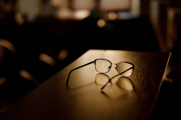 Glasses lay on the table in the evening in a patch of sunlight. A warm, cozy atmosphere. Lost eyeglasses. Sun shines into the room