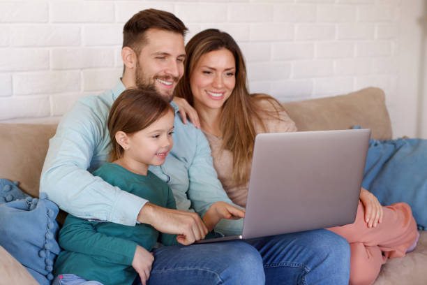 istock Smiling family relaxing at home and using laptop together 1361250104