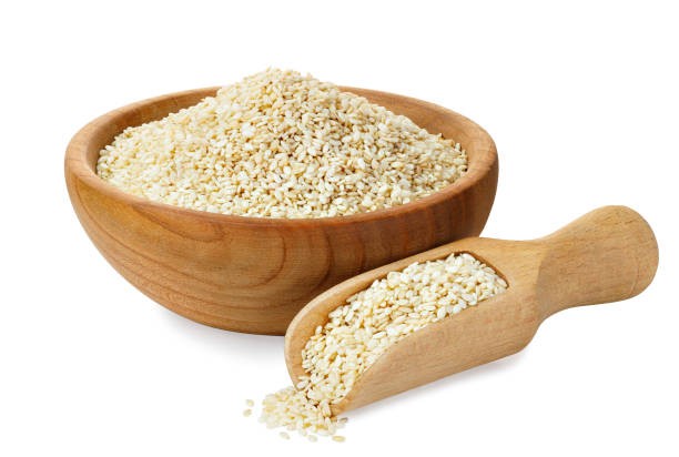 sesame seeds in wooden bowl and scoop isolated stock photo