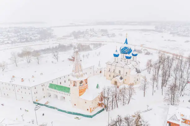Aerial drone view of Suzdal Kremlin and cathedral of Nativity at the Kamenka river, Russia during winter with snow. Suzdal golden ring of Russia.