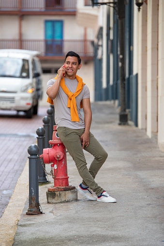 Young latino man in the city talking by mobile phone, Panama City, Central America