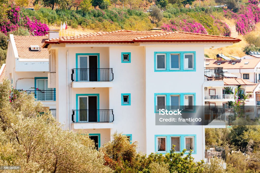 Houses and villas with red roofs in a resort town on mountain steep slope at the Mediterranean Sea. Real estate and urban development concept Mansion Stock Photo
