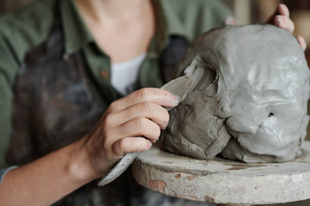 istock Girl making sculpture from clay 1361273041