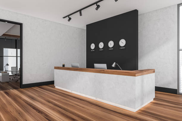 istock Reception interior desk with computers and clocks on the wall 1361273248