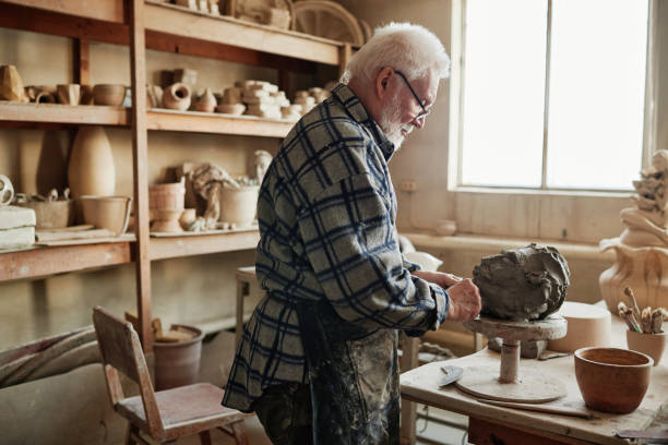 istock Man shaping clay sculpture in the studio 1361273270